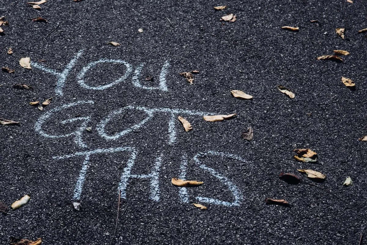 The words “You got this” written in chalk on pavement