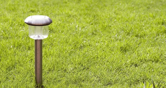 Outdoor path light standing in a green lawn