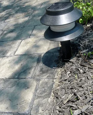 Walkway light installed beside a stone paver path