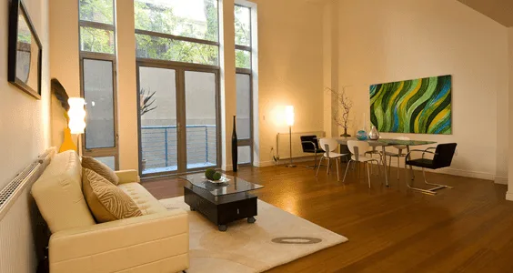 Warmly lit open-plan living and dining room with floor lamps and wall lighting