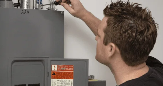 Electrician working on a residential electrical panel with a screwdriver