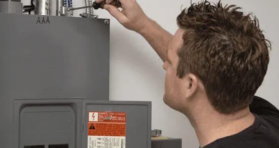 Electrician working on a residential electrical panel with a screwdriver